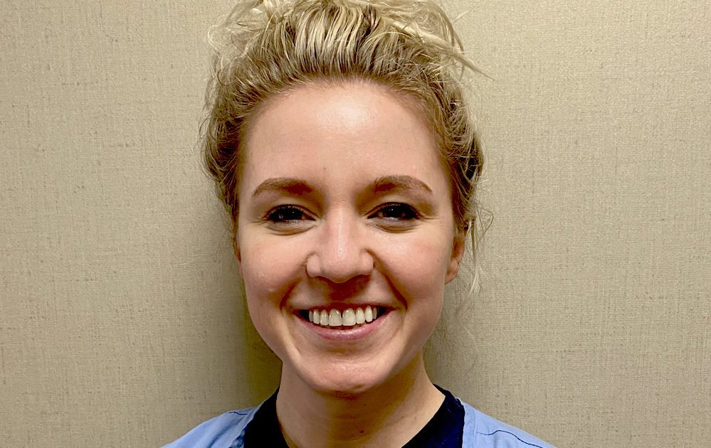 A photo of a woman named Bryanna Sowder smiling and wearing a black shirt with a stethoscope around her neck.